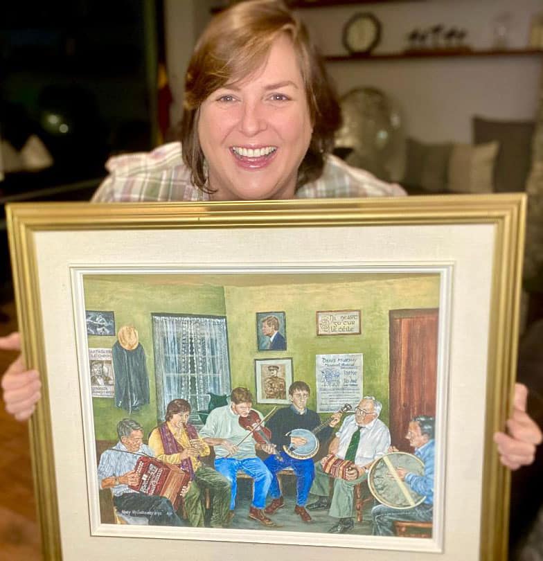 Joanie Madden holding Mary McSweeney painting.